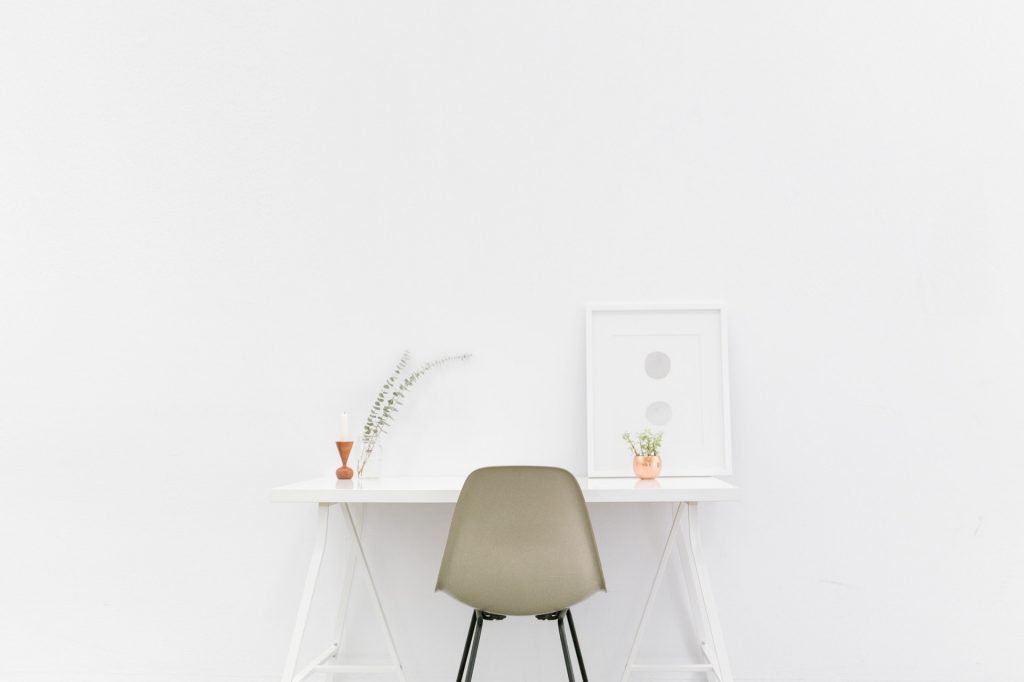 Białe wnętrza - stolik i krzesło na tle białej ściany