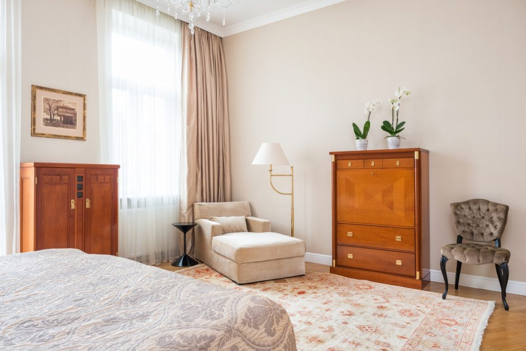 Klasyczna aranżacja sypialni -- meble drewniane i tapicerowane