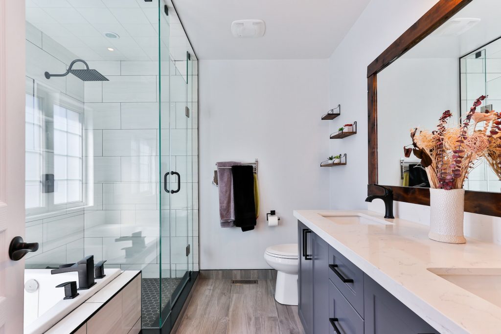 Łazienka z przeszkloną kabina prysznicową i dużym lustrem